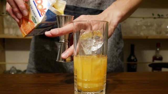 オレンジジュースを注ぐ画像。